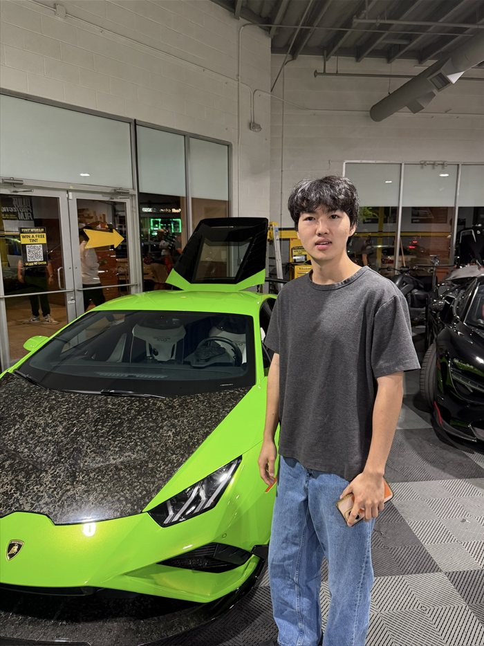 Brandon Lee next to a green Lamborghini with a carbon hood