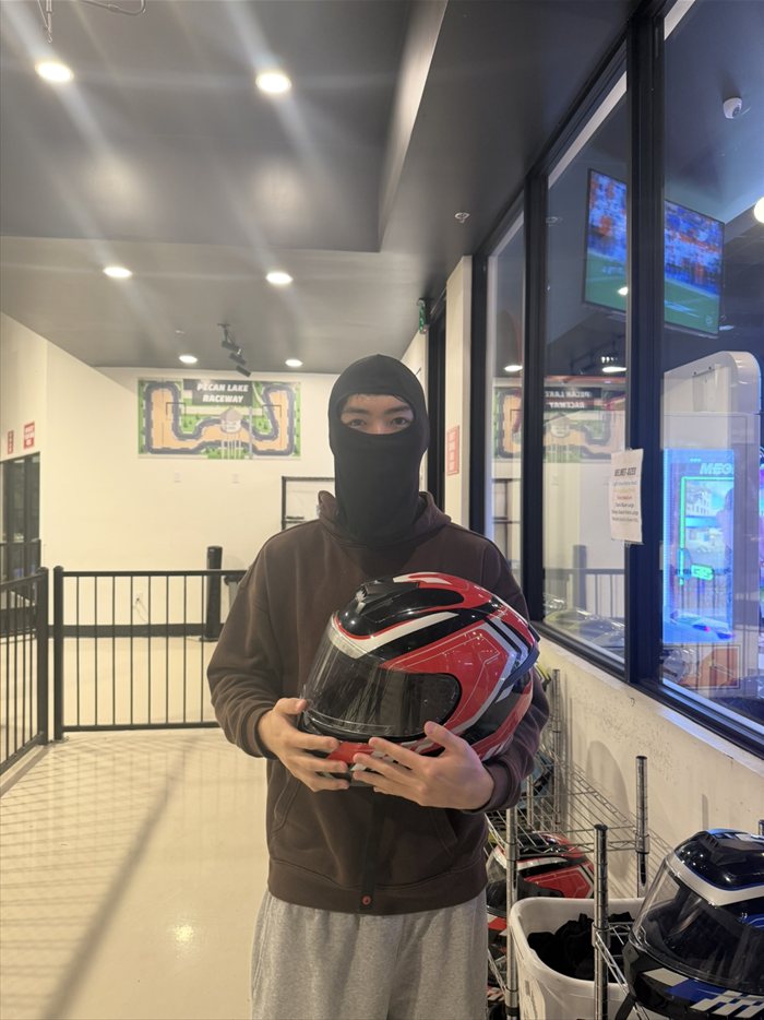 Brandon Lee in a balaclava holding a helmet at Pecan Lake Raceway