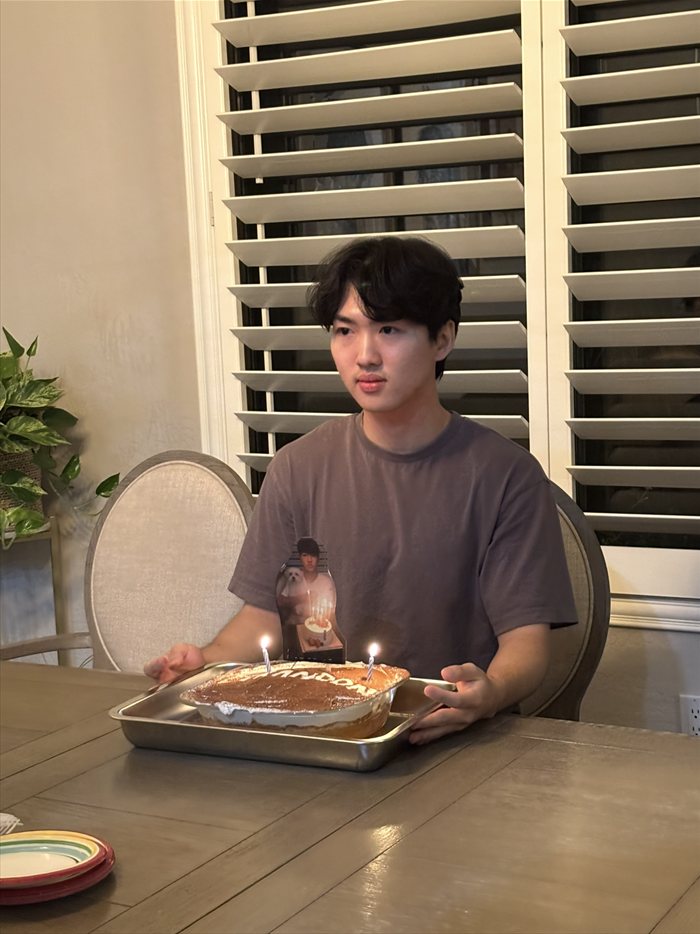 Brandon Lee with a birthday cake and two lit candles
